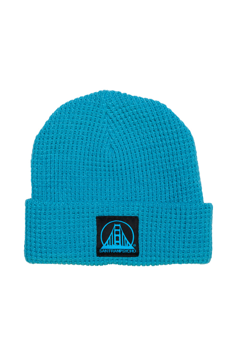 The Cyan Waffle Beanie is crafted from 100% acrylic and features a black/blue logo patch with a bridge design and the text SANFRANSYCHO.