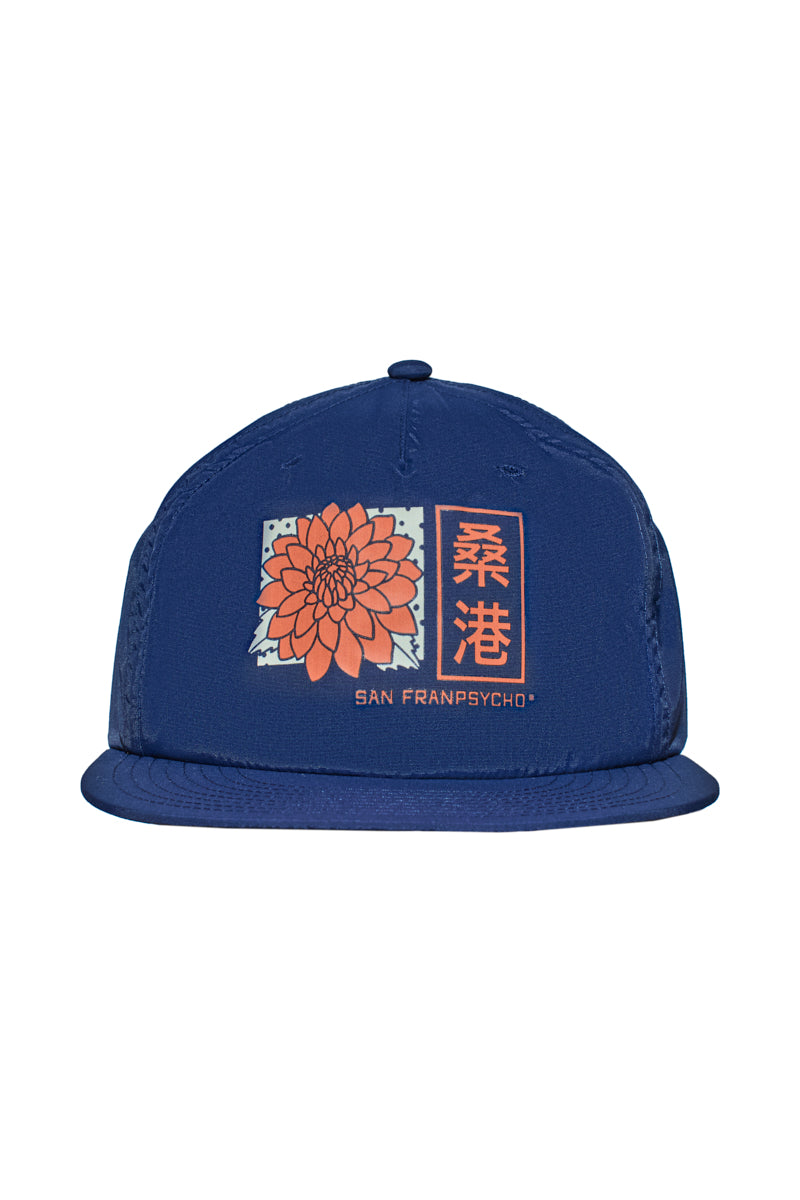 The Sunset Dahlia Hat is a blue snapback featuring an orange flower graphic, Asian-style script above San Franpsycho text, a flat brim, and an adjustable design.