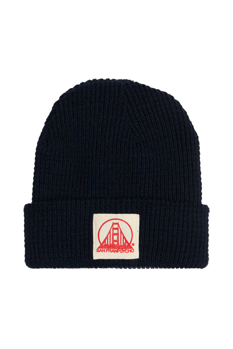 A navy acrylic waffle beanie featuring a patch with a natural and poppy San Francisco logo on the front, showcasing classic San Franpsycho style.