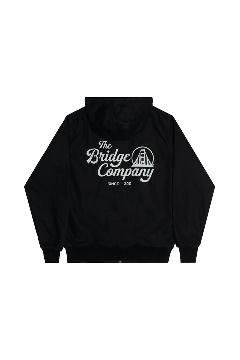 Bridge Co. Workwear Jacket: Black hoodie featuring "The Bridge Company" and a bridge graphic in white on the back, inspired by classic workwear jackets.