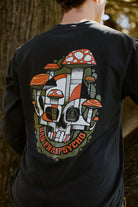 Person wearing the Mind Bloom Long Sleeve, a black graphic tee with a skull and mushroom design and San Franspsycho text on the back.