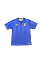 The WC x SFP Jersey - Blue is a short-sleeve soccer top with yellow details, dual crest logos on the chest, and a fan fit—perfect for US Men's National Team supporters and inspired by World Cup jerseys.
