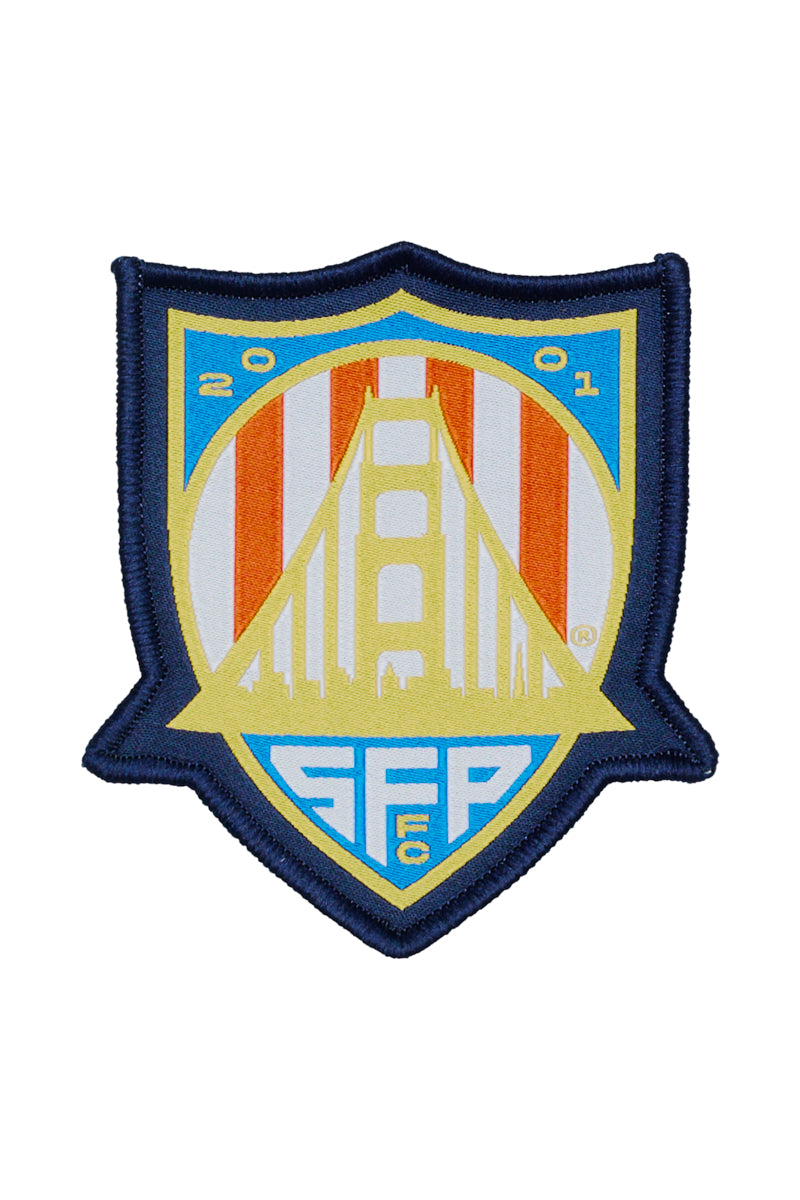 The WC x SFP Patch showcases a soccer badge with the Golden Gate Bridge, “2001” at the top, and “SFFC” at the bottom in blue and yellow—ideal for patches or Team USA fans.