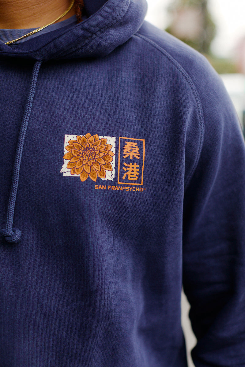Wearing the Sunset Dahlia Pullover Hoodie, which features a yellow flower and Chinese characters above the San Franpsycho logo, hand printed in San Francisco.
