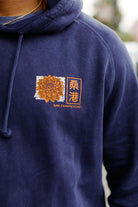 Wearing the Sunset Dahlia Pullover Hoodie, which features a yellow flower and Chinese characters above the San Franpsycho logo, hand printed in San Francisco.