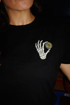 Black Women’s Quarter Cent Tee crop top featuring a graphic of a skeleton hand holding a yellow coin.
