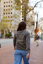 Person wearing a grey 3D Logo Crewneck with a Golden Gate Bridge graphic on the back.