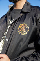 A person wears the Dirty UFO Coaches Jacket in black, showcasing a yellow San Francisco Dirtybird logo on the chest—a standout Bay Area streetwear piece.