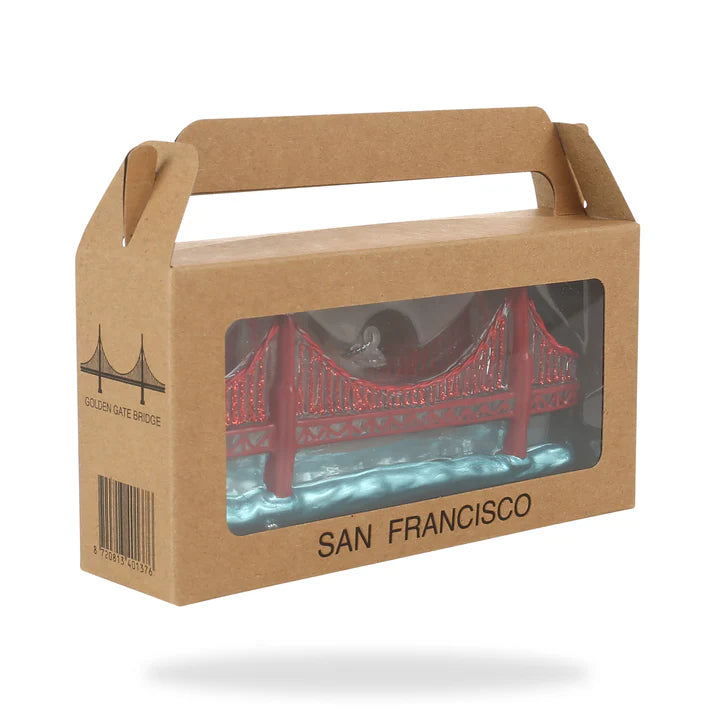 A model of the Golden Gate Bridge packaged in a brown cardboard box with a clear window, from the Xmas Ornaments - Local Elves collection.