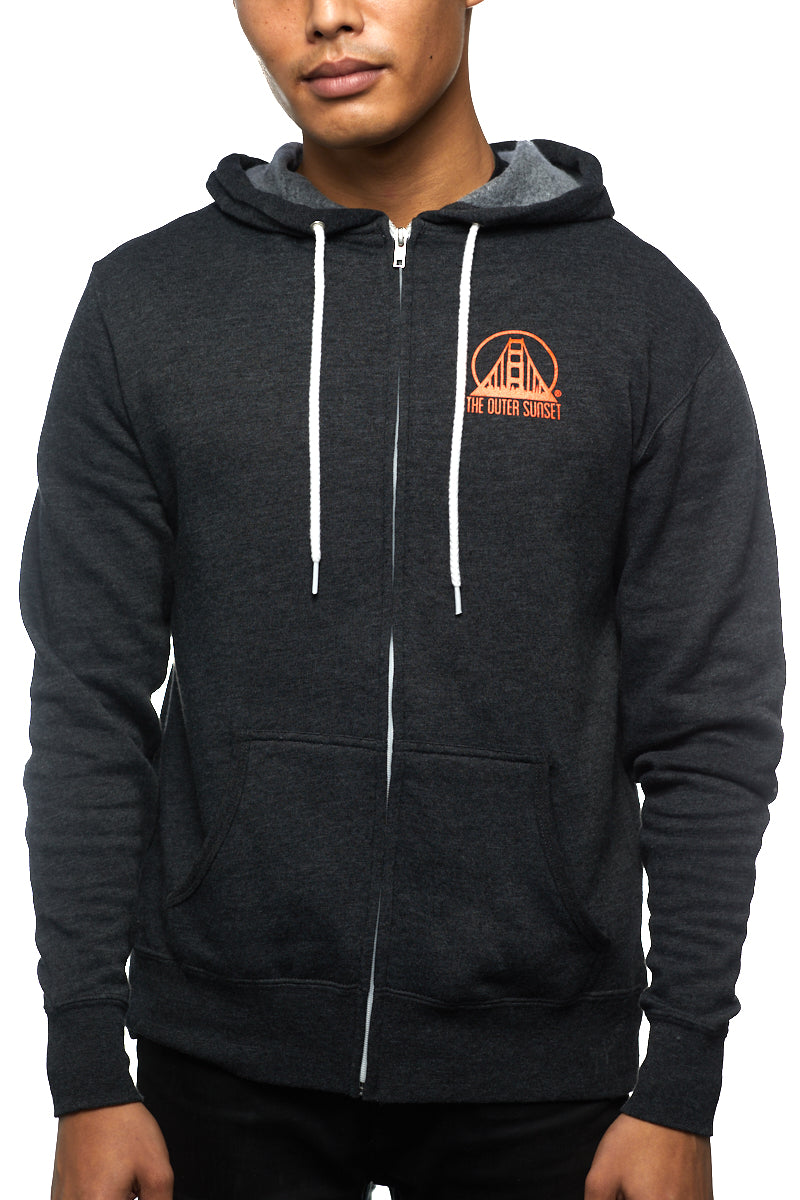 A person strolling down Noriega St in an Outer Sunset Zip-Up Hoodie, proudly displaying the logo on their chest.