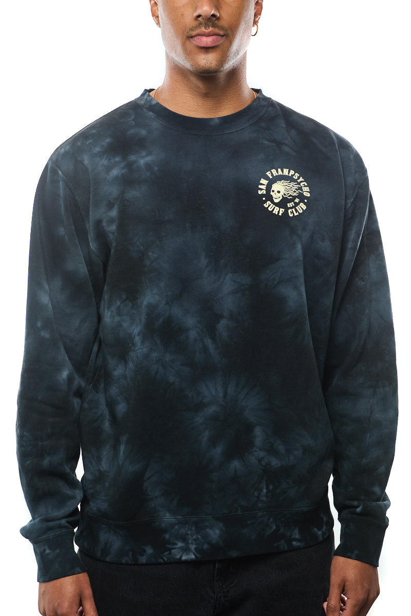 A man wears the Surf Club Crewneck, a super soft black tie-dye sweatshirt featuring a circular logo on the chest.