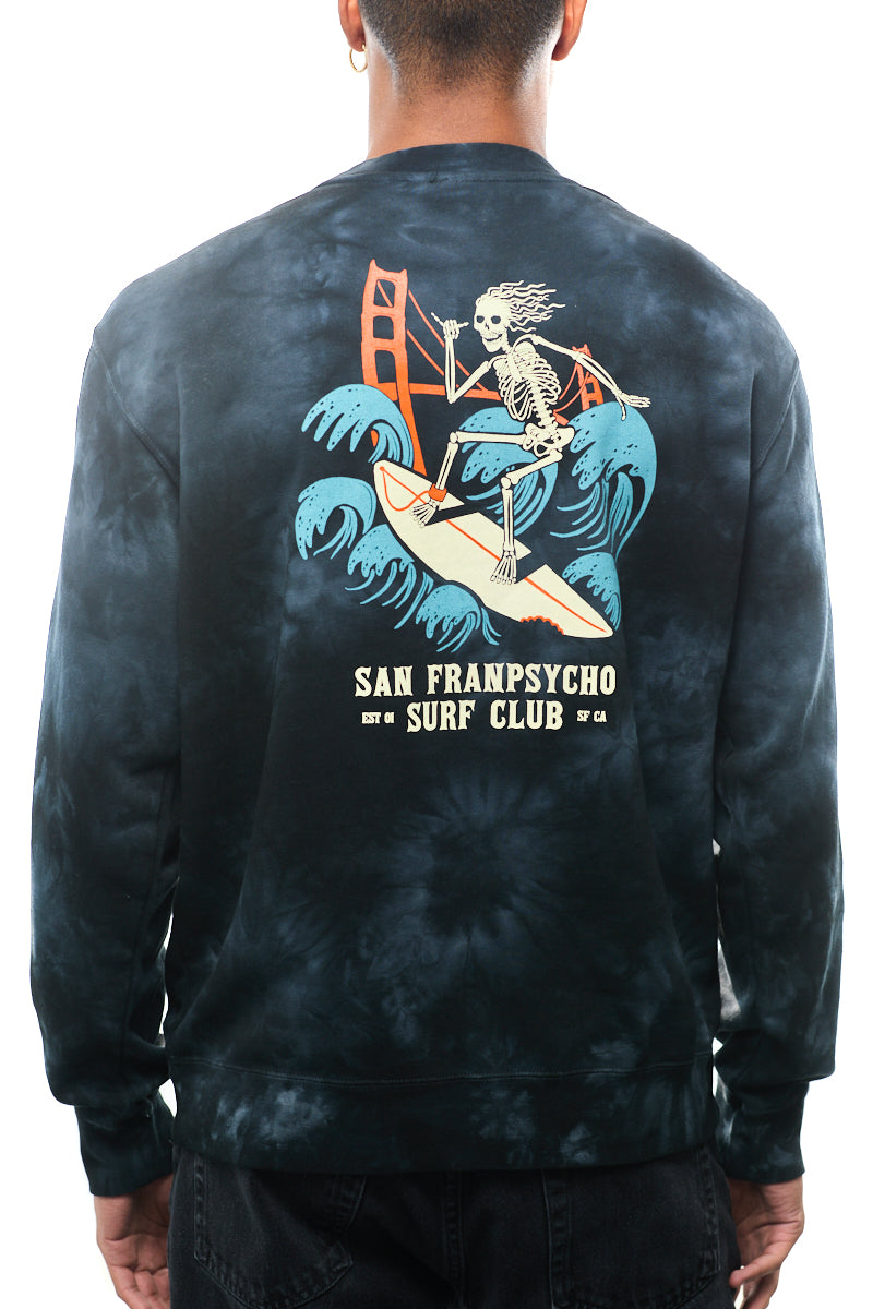 A person wearing the Surf Club Crewneck showcases a skeleton surfing graphic and bold "San Franpsycho Surf Club" text, all in super soft tie-dye.