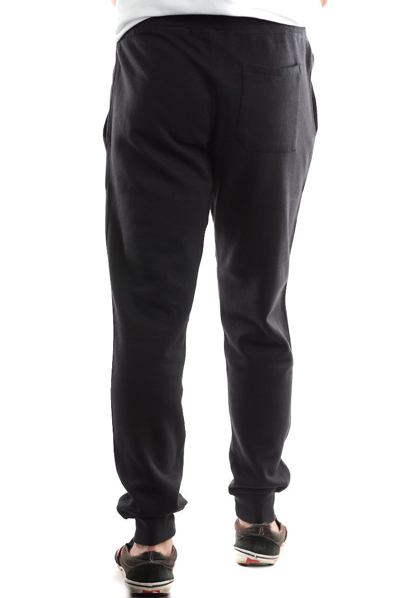 Sporting Black & Orange Embroidered Logo Joggers crafted for comfort and paired with sandals, this person is seen from the back.