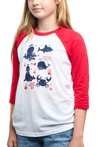 A child wears the Youth Ocean Club Baseball Tee featuring vibrant red sleeves, playful ocean animal illustrations, and the Kids Ocean Club label. Made from 100% cotton, it merges comfort with style.