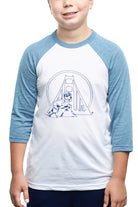The joyful child is sporting a Youth Seal Logo Baseball Tee, made from 100% cotton. This blue and white raglan shirt showcases an adorable bridge and animal design, making it ideal for kids.