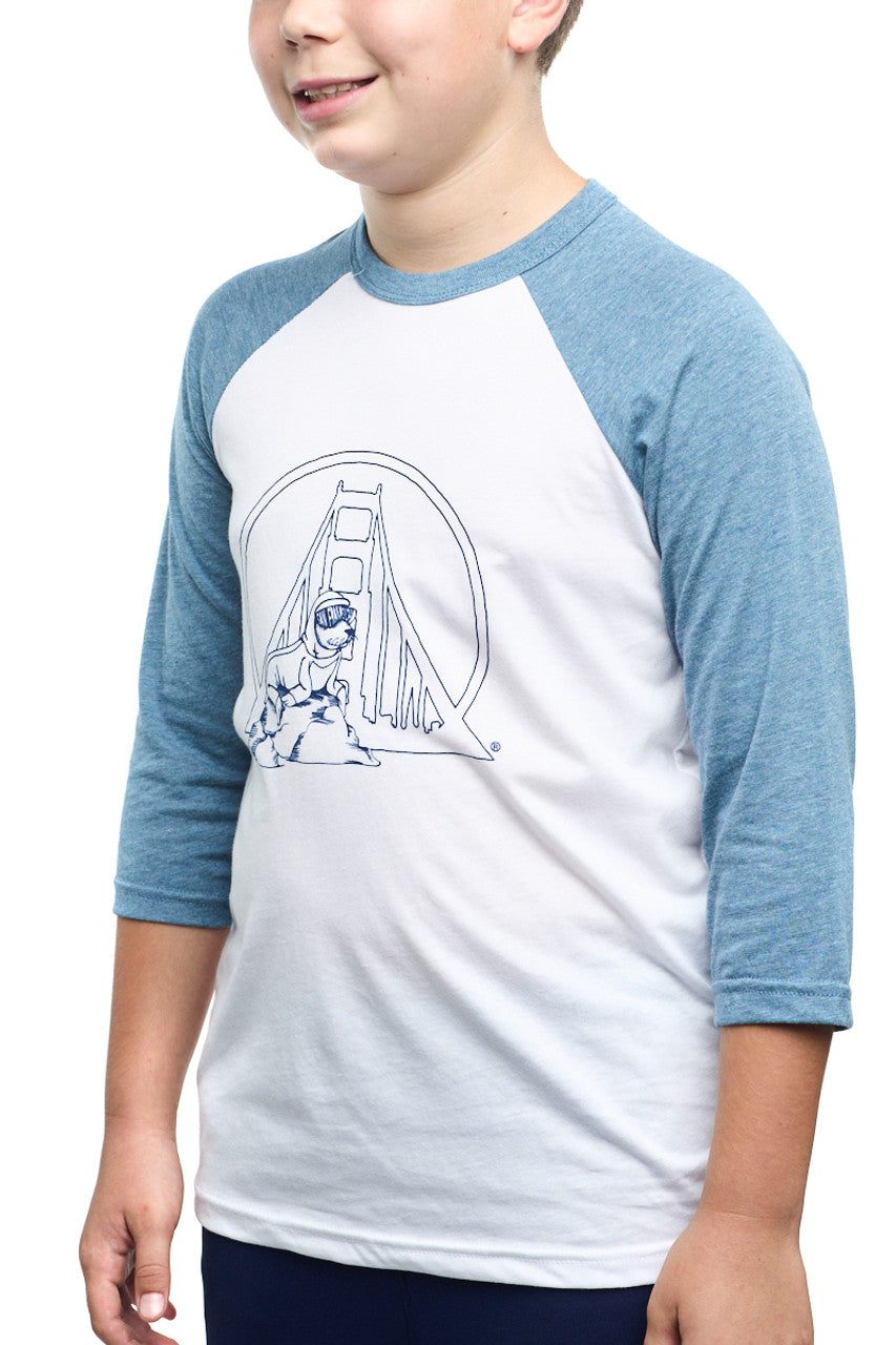 A child wearing a Youth Seal Logo Baseball Tee featuring blue sleeves and a bridge graphic on the front, made from 100% cotton for maximum comfort.