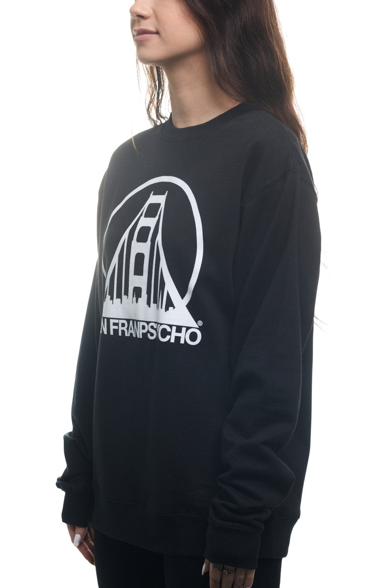 A woman wears the Black & White Logo Crewneck, featuring a classic style in black with a stylized bridge print, the SFP logo, and the text "San Francisco." This sweatshirt is available in various sizes and combines comfort with iconic flair.