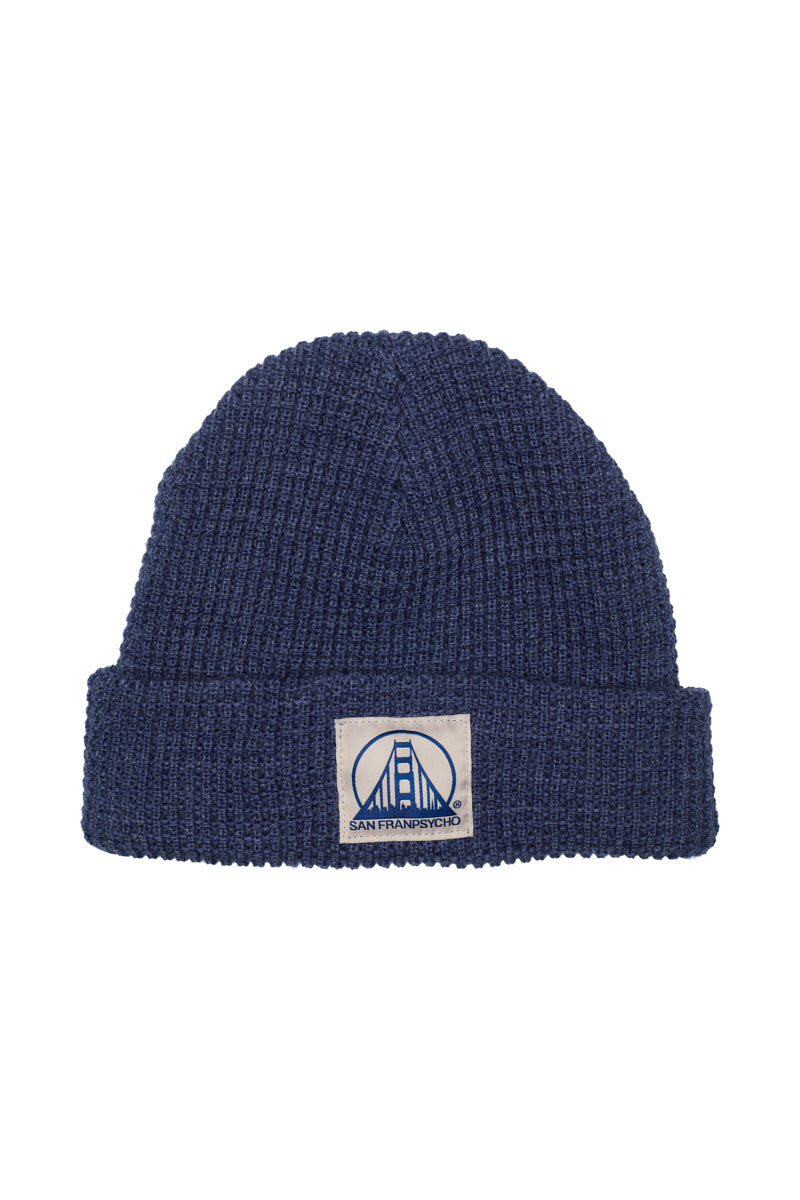 A Denim Heather Waffle Beanie featuring a stylish Natural/Navy San Francisco and bridge logo patch on the front.