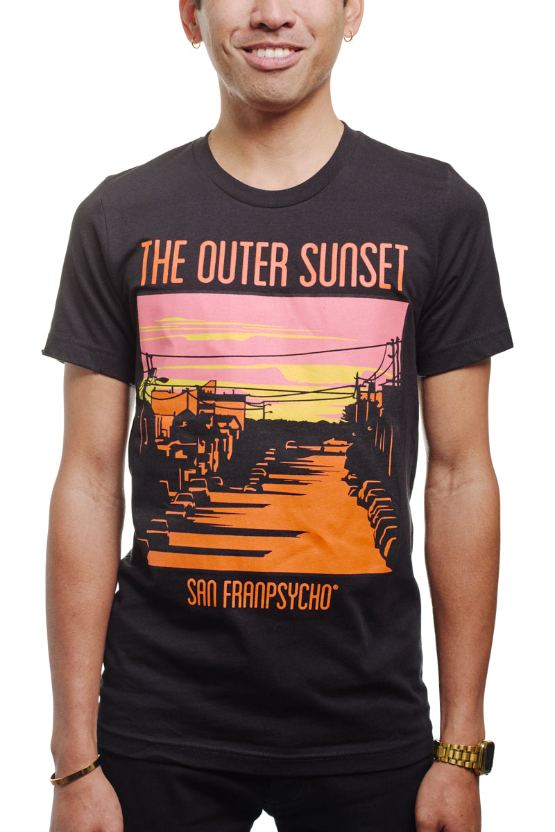 A person wears the Outer Sunset Tee in black, showcasing a vibrant graphic emblazoned with "The Outer Sunset" and "San Franpsycho," embodying the eclectic spirit of San Francisco.