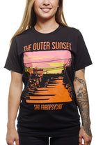 A person wears the Outer Sunset Tee, featuring a vibrant sunset design and the words 'The Outer Sunset San Franpsycho,' embodying the spirit of San Francisco.