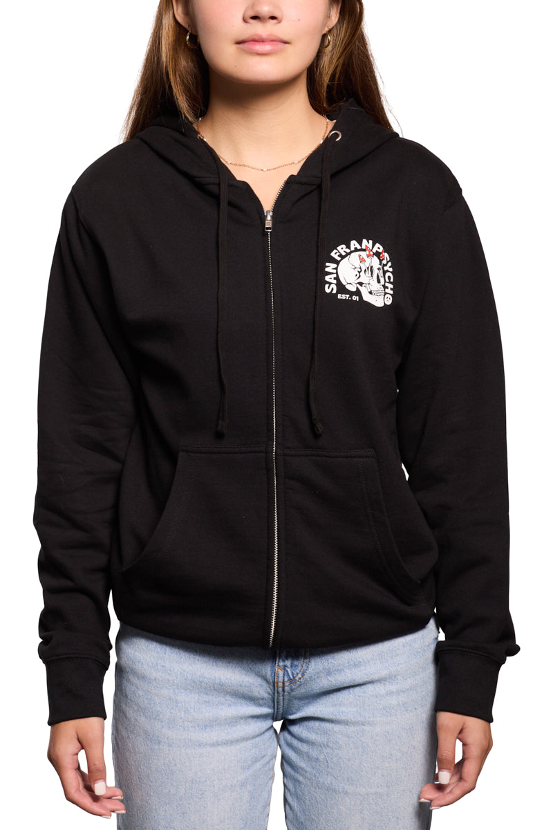 A person dressed in a black Shroom Skull Zip-Up Hoodie featuring the San Fran Psycho logo, made from 100% cotton, teamed with light blue jeans.