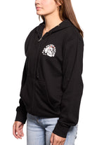 A person wearing a black Shroom Skull Zip-Up Hoodie, hand-printed on 100% cotton and featuring a San Francisco graphic, is paired perfectly with light blue jeans against a crisp white background.