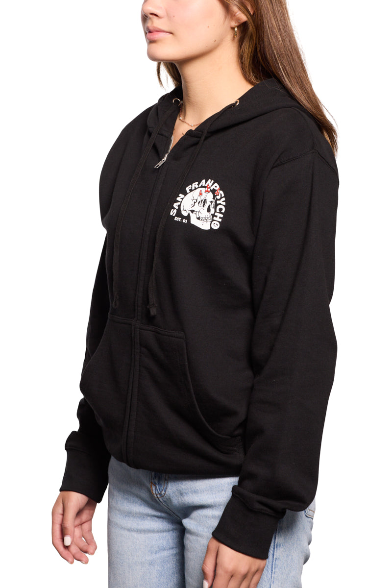 A person wearing a black Shroom Skull Zip-Up Hoodie, hand-printed on 100% cotton and featuring a San Francisco graphic, is paired perfectly with light blue jeans against a crisp white background.