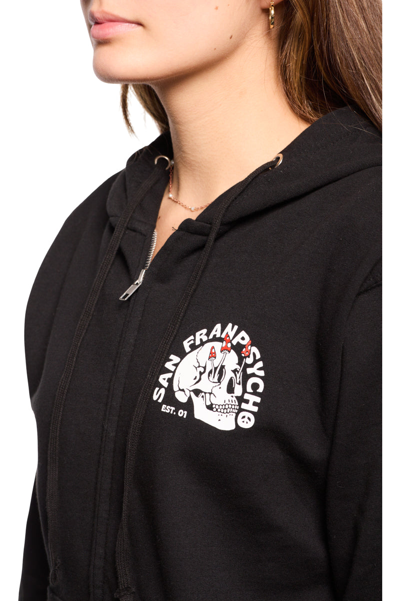 A woman is wearing a Shroom Skull Zip-Up Hoodie, made from 100% cotton in black. It features a striking graphic Shroom Skull design and the "San Franpsycho EST. 01" text, all expertly hand printed for lasting quality.