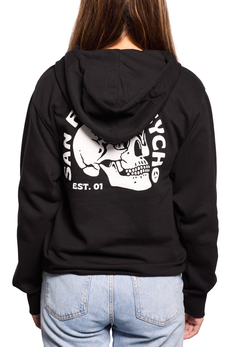 Rear view of a person wearing a hand-printed Shroom Skull Zip-Up Hoodie featuring a skull graphic and text, effortlessly paired with light blue jeans.