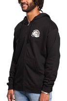 A person wearing a black Shroom Skull Zip-Up Hoodie featuring a white graphic stands against a white background. The hand-printed design pops on the 100% cotton fabric, providing both comfort and style.