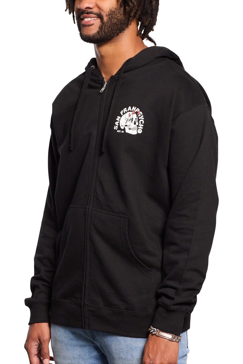 A person wearing a black Shroom Skull Zip-Up Hoodie featuring a white graphic stands against a white background. The hand-printed design pops on the 100% cotton fabric, providing both comfort and style.