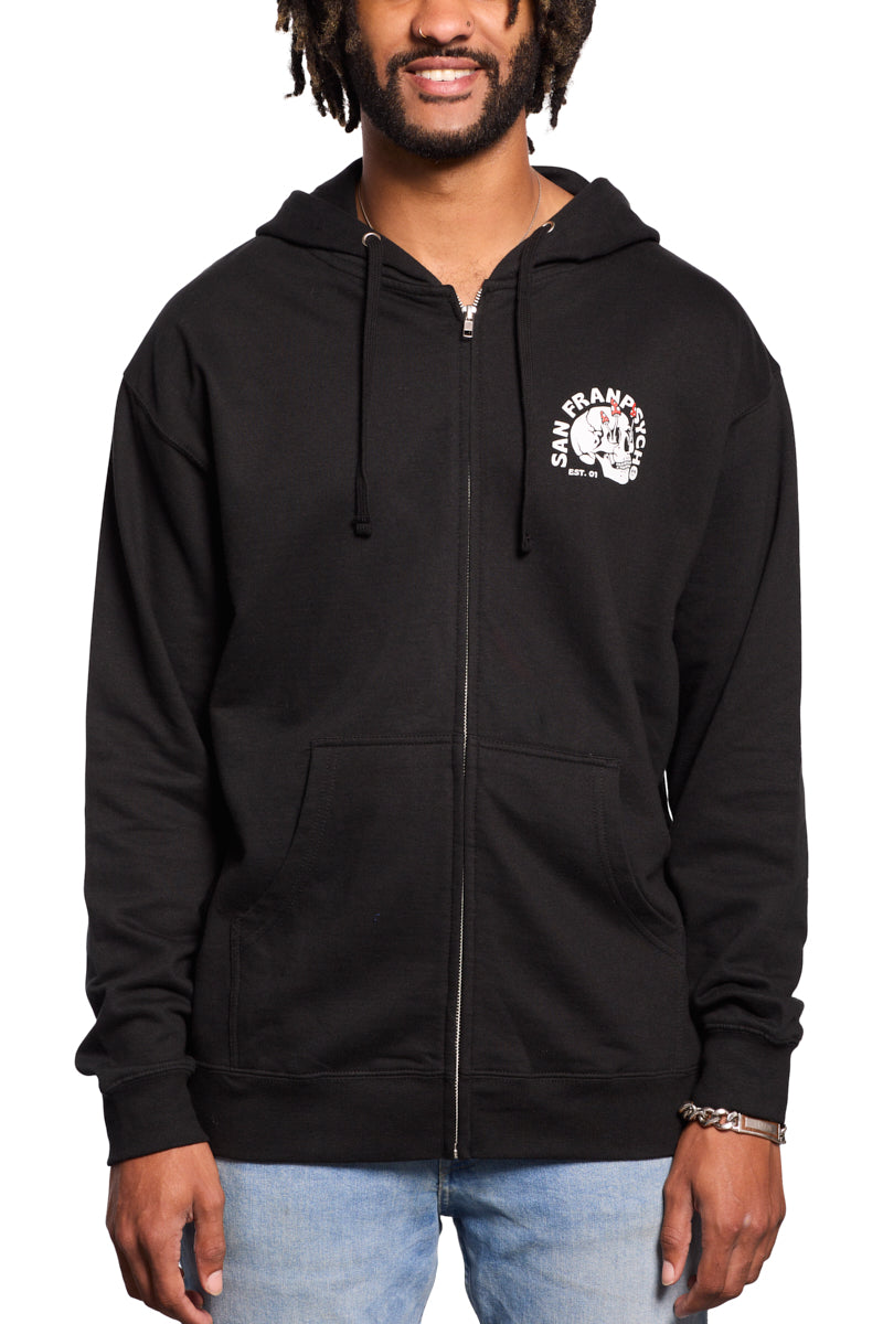 A man wearing a Shroom Skull Zip-Up Hoodie, made of 100% cotton in black with "San Francisco" and a hand-printed graphic on the chest, smiles while standing against a white background.