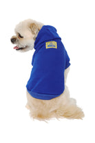 A fluffy white dog sits facing away in the Blue Dog Hoodie w/Yellow/Blue Logo Patch, offering warm comfort for those chilly days.