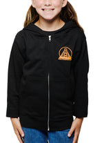 A child in a Youth Black & Orange Logo Zip-Up Hoodie smiles with hands in pockets against a white background.