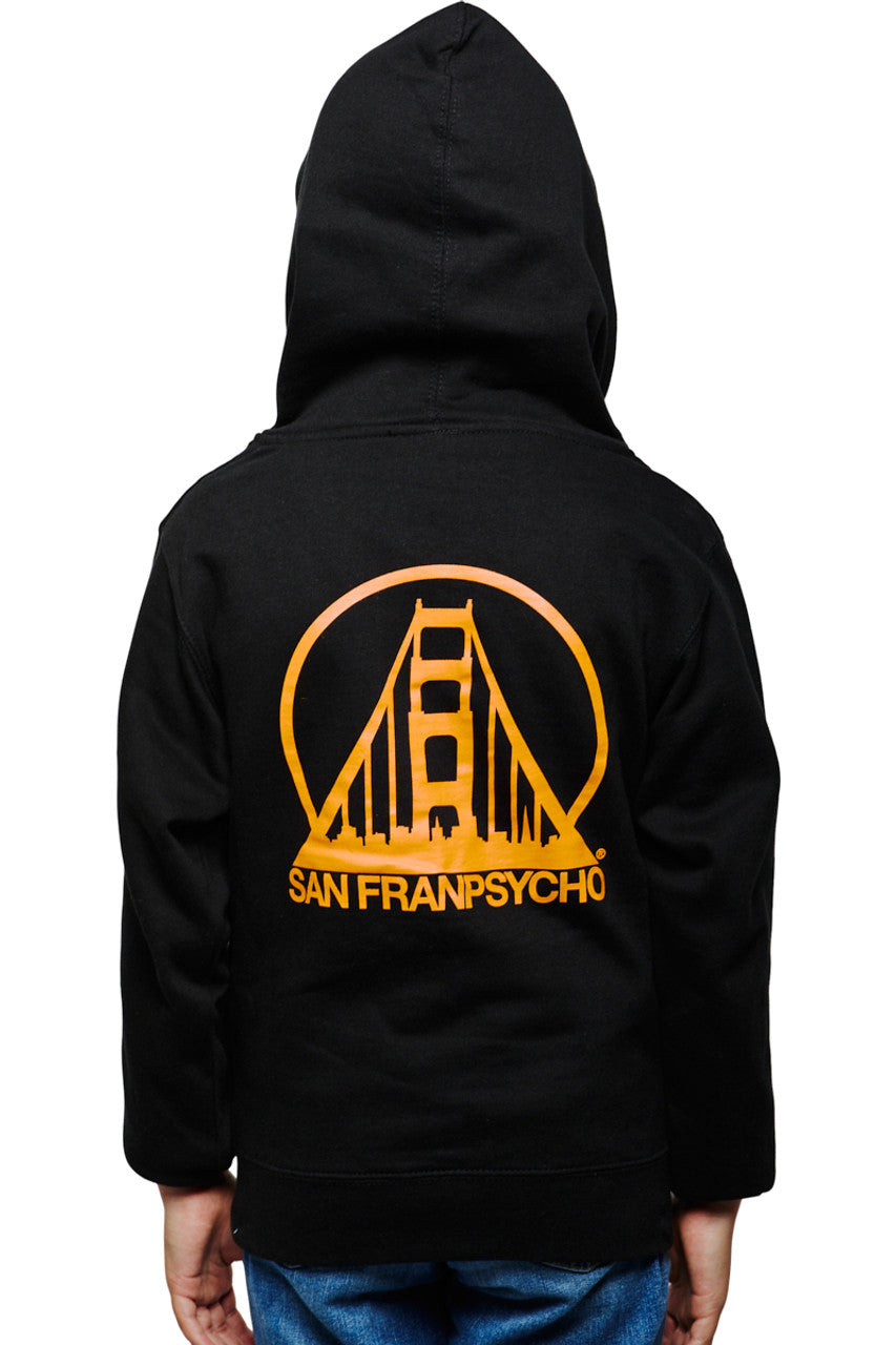 Child in the Youth Black & Orange Logo Zip-Up Hoodie made from 100% cotton, featuring the San Franpsycho and orange bridge design on the back, paired with blue jeans.