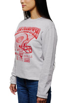 A person wearing the Candlestick Champs Crewneck, a vintage gray sweatshirt featuring a red football helmet design representing the Niners season, paired with blue jeans.