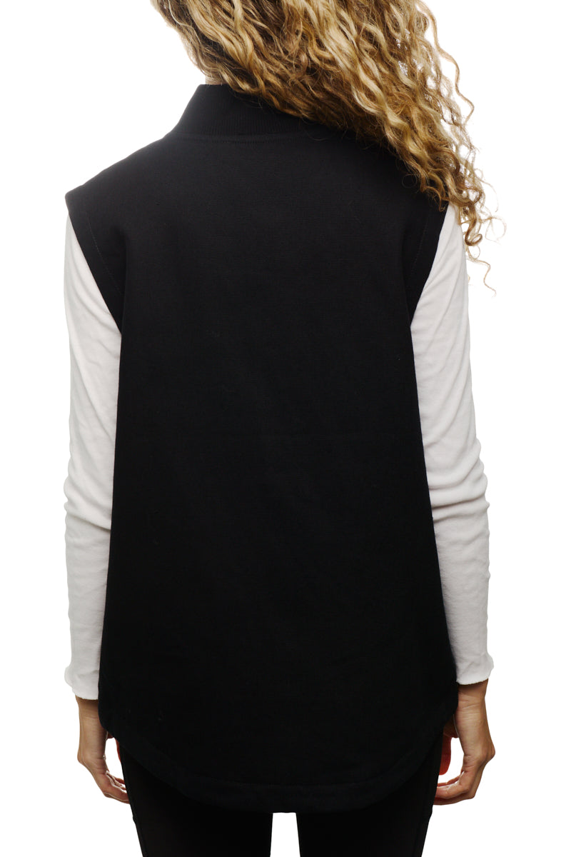 A woman with curly hair is seen from the back, wearing the Leather Patch Workwear Vest over a white long-sleeve shirt, crafted from 100% cotton for that perfect fit.
