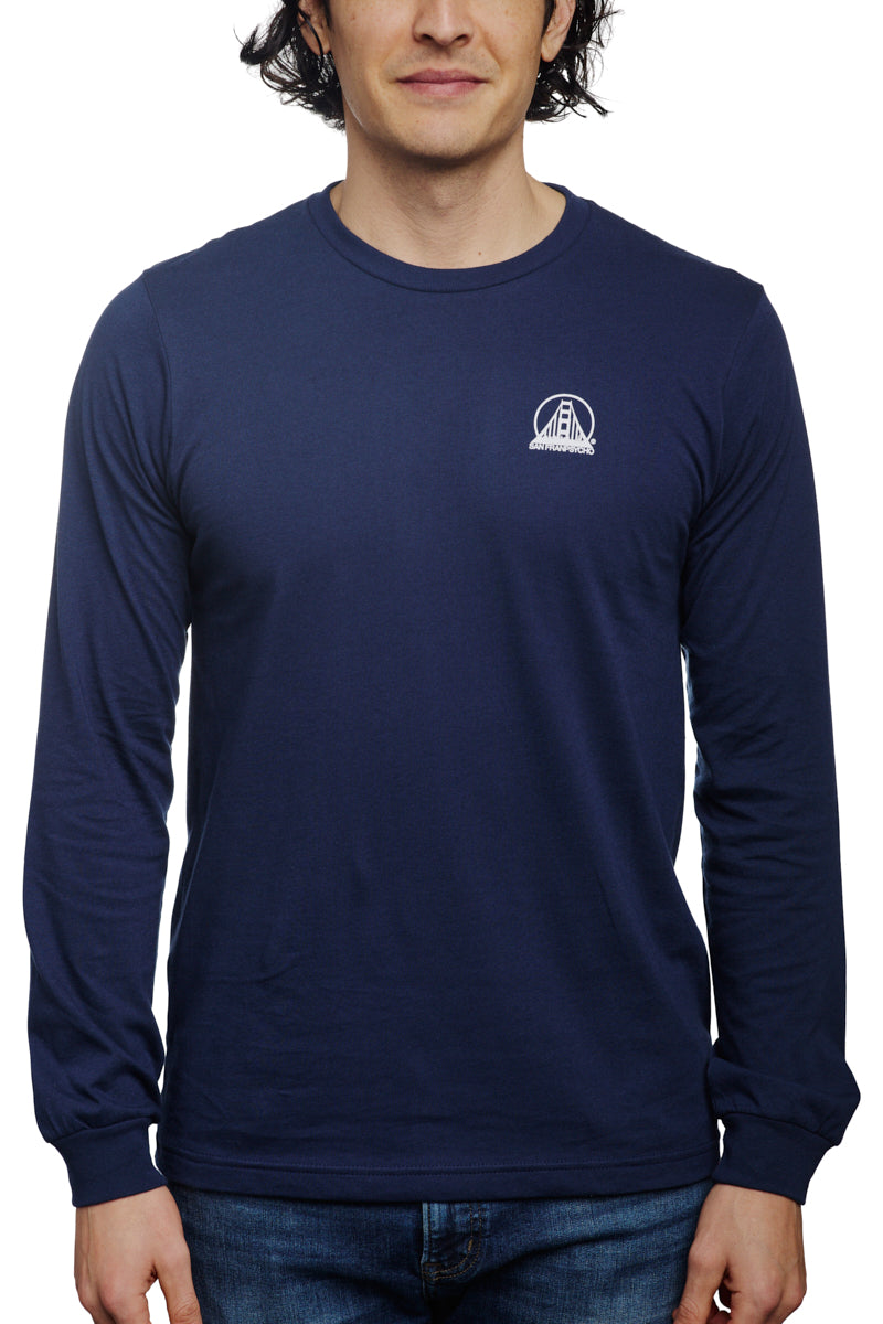 A person models the Navy Long Sleeve Mini Logo tee made from soft Airlume cotton with a small white logo, paired with jeans, set against a white background.