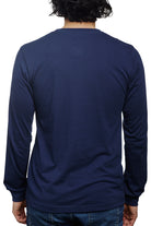 A person is seen from behind against a crisp white background, wearing the Navy Long Sleeve Mini Logo tee made from soft Airlume cotton, paired with jeans.