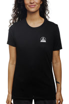 A person is wearing a Women's Mini Logo Tee in black from the basics line, standing against a plain background.