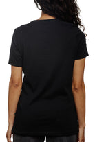 A person with long hair is wearing a Women's Mini Logo Tee in black from the basics line, facing away.
