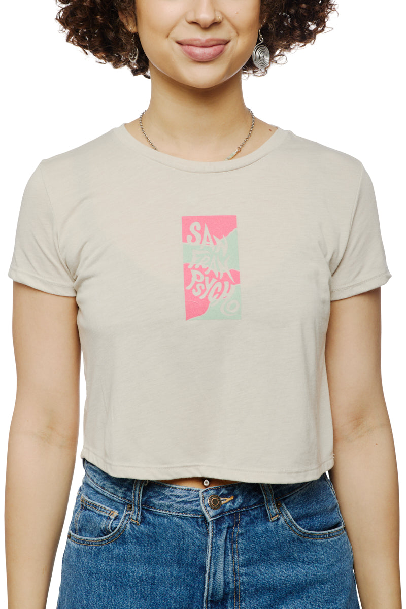 A person wearing a cream Trippy Psycho Crop Top featuring a pastel graphic paired with blue jeans, hand-printed in San Francisco.