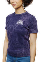 A woman is wearing the Psycho Invader Mineral Wash Tee from the Spring 2023 Collection, showcasing the San Franpsycho logo. She pairs it with earrings and blue jeans, effortlessly merging style and comfort.