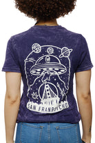 A person is viewed from behind, sporting a purple Psycho Invader Mineral Wash Tee featuring a captivating UFO and planets design, labeled San Francisco. This standout piece from the Spring 2023 Collection draws attention with its bold artwork.