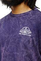 Wearing the Psycho Invader Mineral Wash Tee from the Spring 2023 Collection, a person proudly showcases a UFO logo accompanied by SAN FRANPSYCHO text, truly embracing the Psycho Invader style.