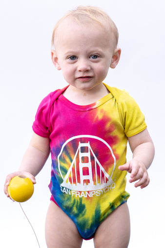 A pink and yellow hand-printed Tie-Dye Onesie featuring a Golden Gate Bridge graphic.